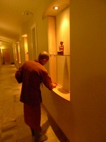 Tan Suvijjano cleans the hallway shrine