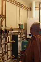 Luang Por Liem takes a look inside the machine room in the bhikkhu vihara