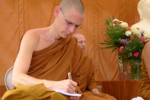Ajahn Thaniyo takes notes in preparation to translate Luang Por Liem's talk