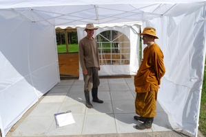 Peter V and Samanera Khema stand on the newly finished main entrance to the tent