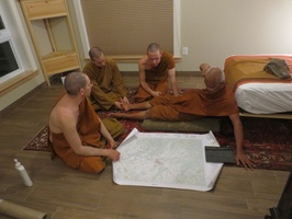 Luang Por Liem and the Sangha look at a map of the Perth area.  L to R: Tan Cunda, Samanera Khema, Tan Thaniyo, Luang Por Liem