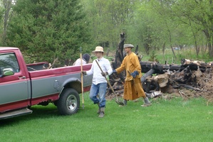 L to R: Beatrice, Adam, and Ven. Atulo work to clear the remnants of a burn pile in front of the bhikkhu vihara