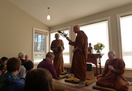 Luang Por Viradhammo sprinkles water as the Sangha chants a blessing