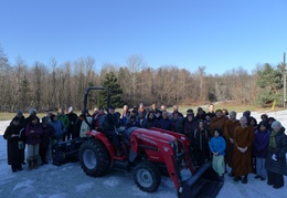 Attendees of the opening of the new bhikkhu vihara take a group photo in front of the new tractor