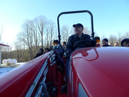 The bhikkhu vihara's architect, Eddie Edmunson, has his photo taken in the driver's seat of the new tractor
