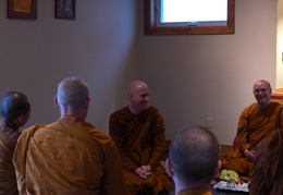 Members of the Sangha sit an anjali after paying respects to Ajahn Jayanto
