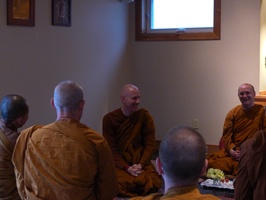 Members of the Sangha sit an anjali after paying respects to Ajahn Jayanto