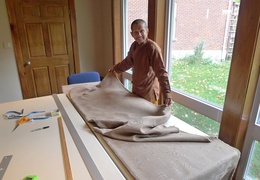 Tan Suvijjano works on the fabric for our new meditation mats