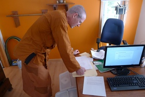 Ven. Khemako looks over plans for the monastery's computer network