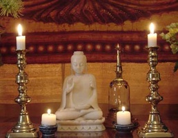 A Buddha statue adorns the sign