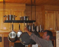 Bo hangs a pan in the kitchen