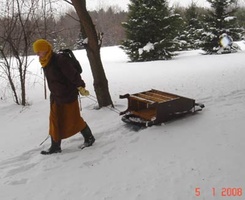 Bhante Khemaratana moves some furniture on a sled