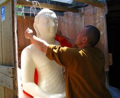 Ajahn Kusalo takes the new Buddha out of its' crate