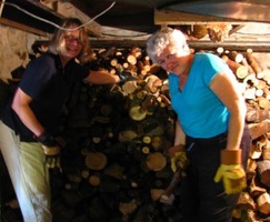Heather (L) and Denny (R) get some wood stacked in the basement of the barn