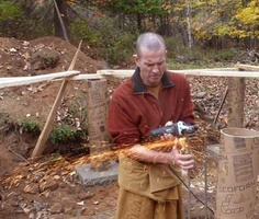 Ajahn Kusalo grinds some re-bar at the new kuti construction site