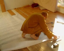 Ajahn Kusalo lays down flooring at the new kuti