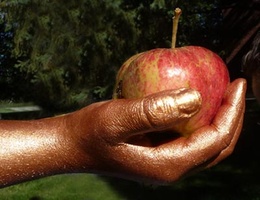 A fresh apple in a painted hand at family camp
