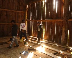 A group works to put a floor down in the barn