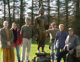 The working bee crew takes a photo with the standing Buddha
