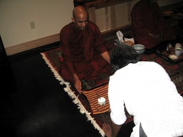 Harini offers a visiting monk a tray