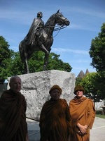 The bhikkhus take a photo in front of a statue of the Queen at parliament