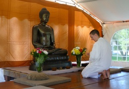 Anagarika in front of Buddha statue